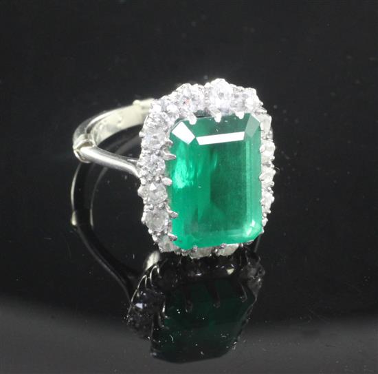 A platinum, emerald and diamond cluster ring, size O.